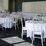 Round tables with white table clothes and purple finishes for an elegant wedding